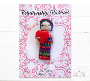 Guatemalan worry doll holding a red heart